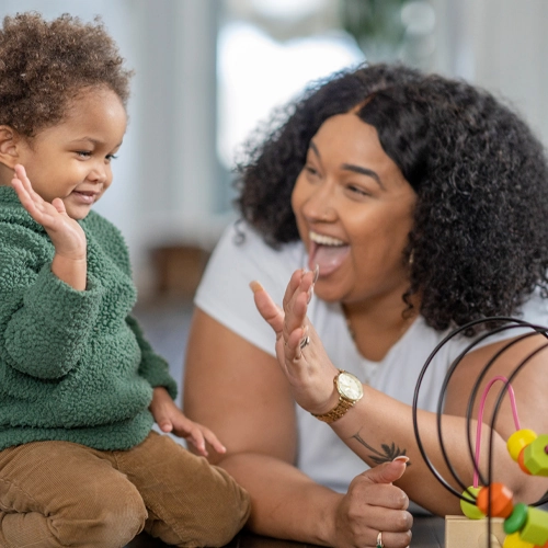 A woman and toddler prepare to high five each other